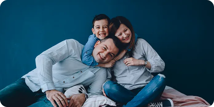 Familie fericită în curte, în fața casei